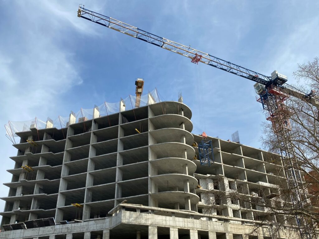 Grúa de construcción sobre paisaje urbano de Tijuana, con enfoque en inflación en la construcción