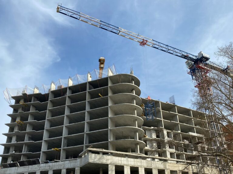 Grúa de construcción sobre paisaje urbano de Tijuana, con enfoque en inflación en la construcción