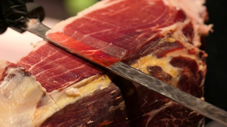 Jamón ibérico en mesa elegante con caja corporativa, símbolo de regalos empresariales en España