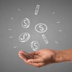 Mano extendida con íconos flotantes de dinero representando la cuesta de enero