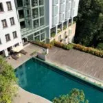 Viajero corporativo mexicano trabajando en remoto, en entorno relajado, combinando slow travel con productividad empresarial