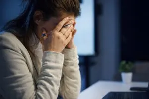 Mujer con expresión de ansiedad en su lugar de trabajo, reflejo del estrés financiero laboral