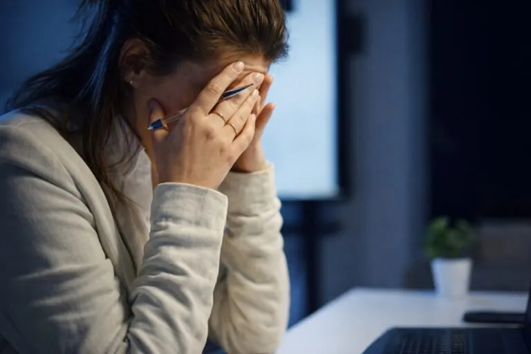 Mujer con expresión de ansiedad en su lugar de trabajo, reflejo del estrés financiero laboral