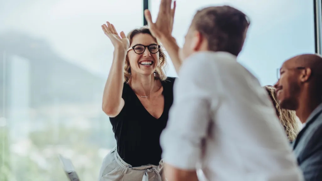 Ambiente laboral positivo con empleados colaborando motivados que reflejan cultura laboral y bienestar organizacional