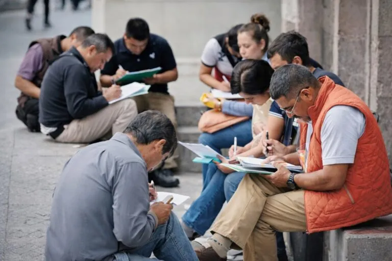 Personas mexicanas llenando solicitudes de empleo en espacios públicos, reflejando el panorama del empleo en México en 2026