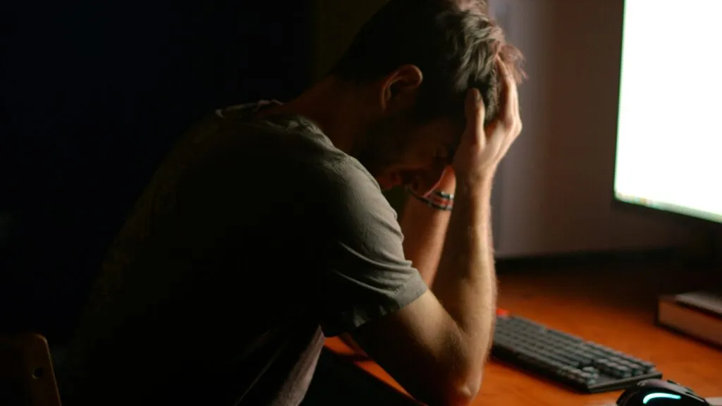 Profesional frente a computadora usando inteligencia artificial mientras enfrenta burnout y aumento de presión laboral