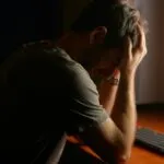 Profesional frente a computadora usando inteligencia artificial mientras enfrenta burnout y aumento de presión laboral