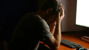 Profesional frente a computadora usando inteligencia artificial mientras enfrenta burnout y aumento de presión laboral