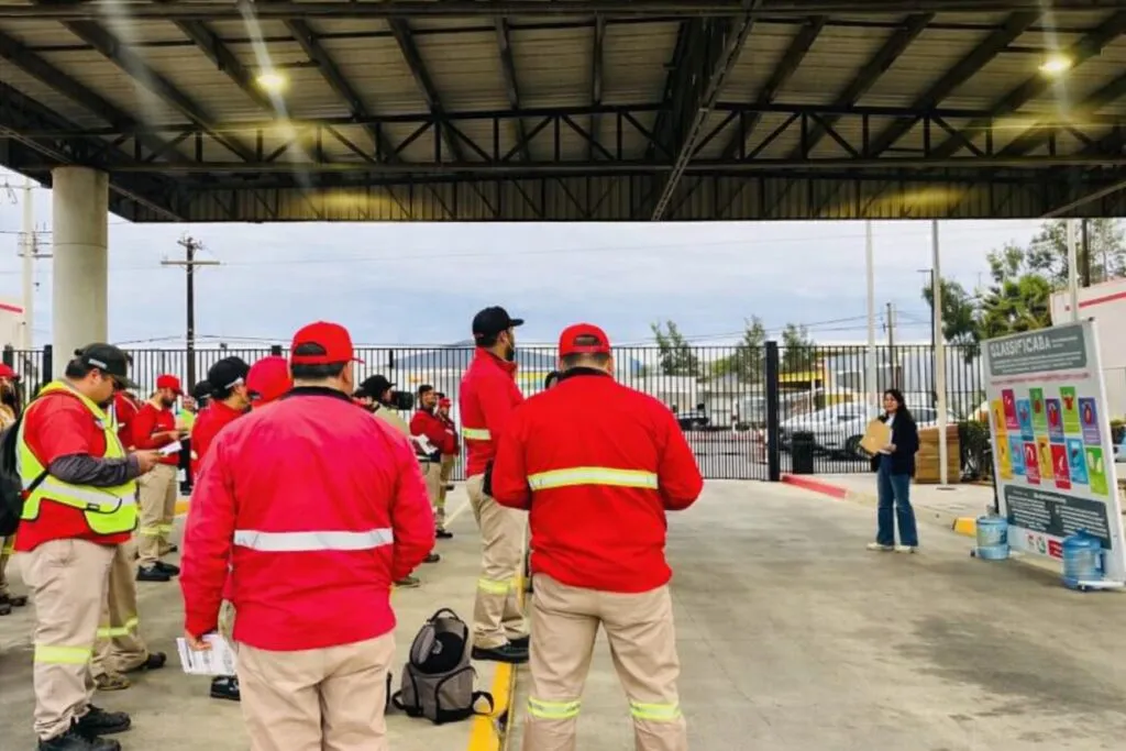 Empleados uniformados de una empresa en Tecate atienden una plática sobre prevención de extorsión telefónica como parte de la cultura empresarial