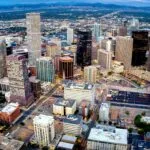 Vista panorámica de Denver con edificios de negocios, arte urbano y naturaleza reflejando turismo y oportunidades empresariales