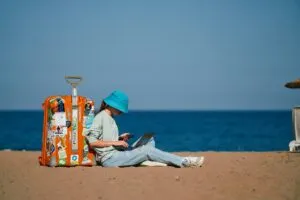 Trabajador en la playa revisando su celular con expresión concentrada, símbolo de no desconectarse del trabajo