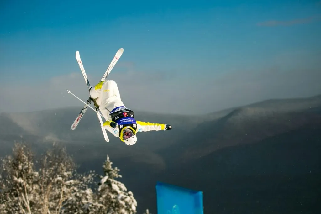 Saltador de esquí con traje técnico durante competencia, tecnología y regulación deportiva en foco