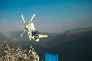Saltador de esquí con traje técnico durante competencia, tecnología y regulación deportiva en foco