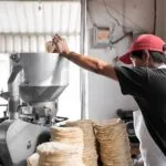 Tortillería tradicional y producción industrial representando la industria de la tortilla en México y su expansión global