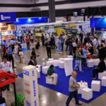 Empresarios en Pabellón Suiza mostrando soluciones tecnológicas en Expocomer Panamá