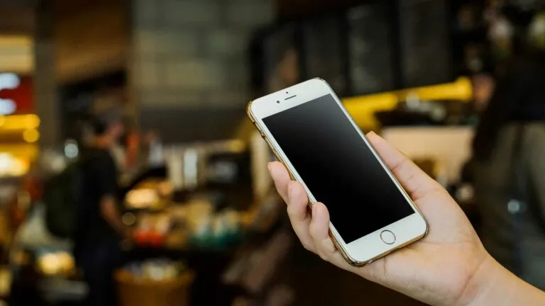 Personas revisando celulares en Cuba con precios elevados por inflación y escasez tecnológica