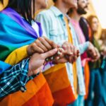 equipo diverso en oficina moderna mostrando allyship corporativo LGBTQ constante e inclusión empresarial innovadora