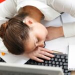 Empleado cansado en oficina refleja cómo la falta de sueño reduce productividad laboral en España y afecta el rendimiento empresarial