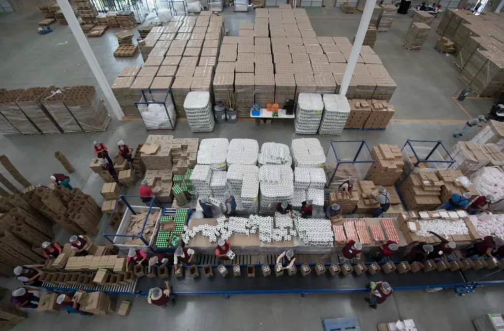Centro logístico de La Cosmopolitana con personal supervisando almacenamiento y distribución de alimentos para instituciones.