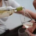 Botella y copas de vino blanco representan nuevas tendencias de consumo y renovación de productos entre las bodegas internacionales.