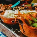 Cultura alimentaria representada mediante diferentes alimentos y tradiciones gastronómicas compartidas alrededor de una mesa.