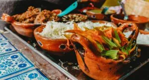 Cultura alimentaria representada mediante diferentes alimentos y tradiciones gastronómicas compartidas alrededor de una mesa.