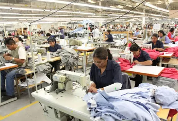 Trabajadores de la industria textil mexicana elaboran prendas de vestir en una fábrica nacional.