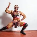 Luchadora mexicana Olympia durante una presentación deportiva, representando su trayectoria entre la lucha libre y el fisicoculturismo.