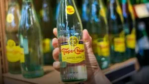 Botellas de agua mineral Topo Chico que representan la reactivación de su distribución en Texas por parte de Coca-Cola.